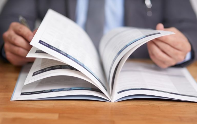 Cropped shot of an unidentifiable man reading a book