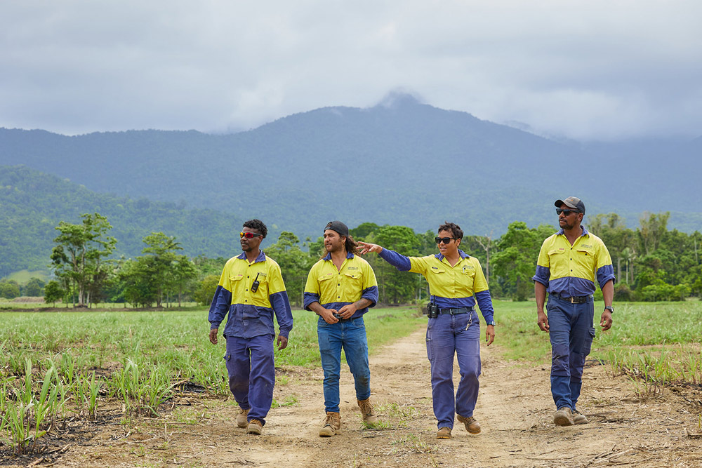 4 men walking along a dirt road